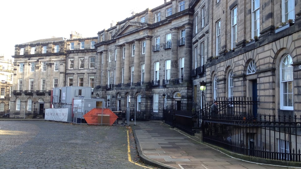 Moray Place 的弧形乔治亚联排住宅沿鹅卵石街道延伸，铁栏杆连成完整街面。