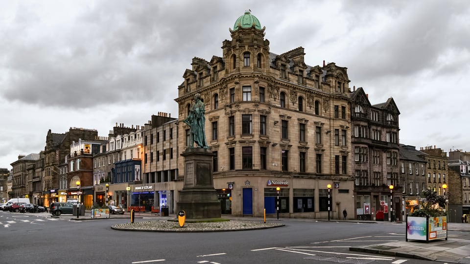 George Street 的 George IV 雕像立在 New Town 石砌街区与圆顶转角楼前。