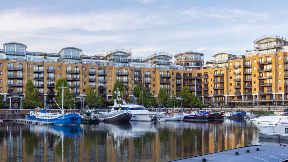 St Katharine Docks 的游艇停泊在 East Dock，弧形屋顶与砖砌公寓围住平静水面。