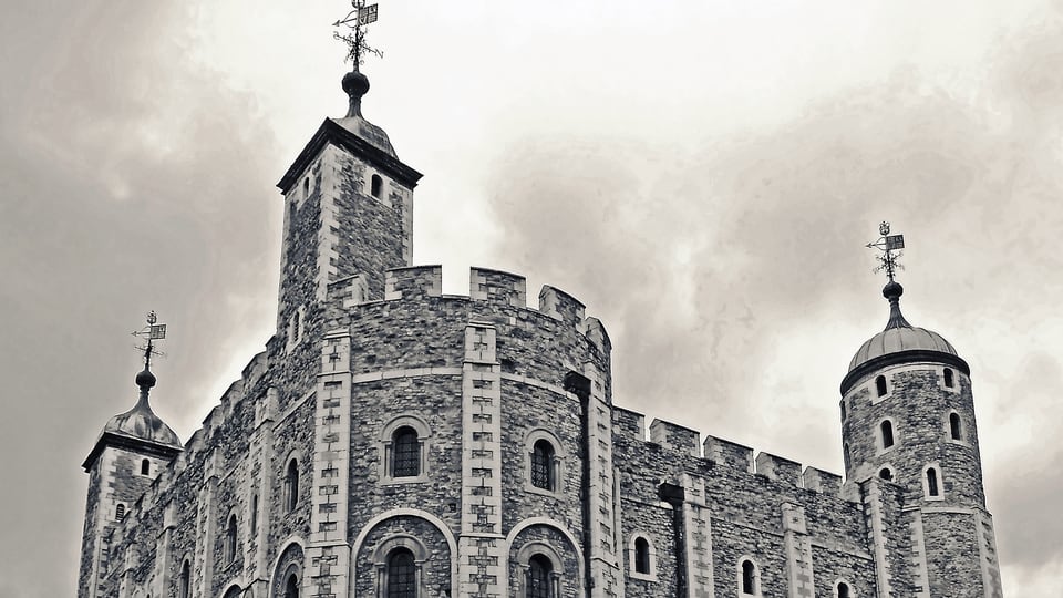 Tower of London 的 White Tower 石墙、圆角塔楼与雉堞从近处仰视展开。