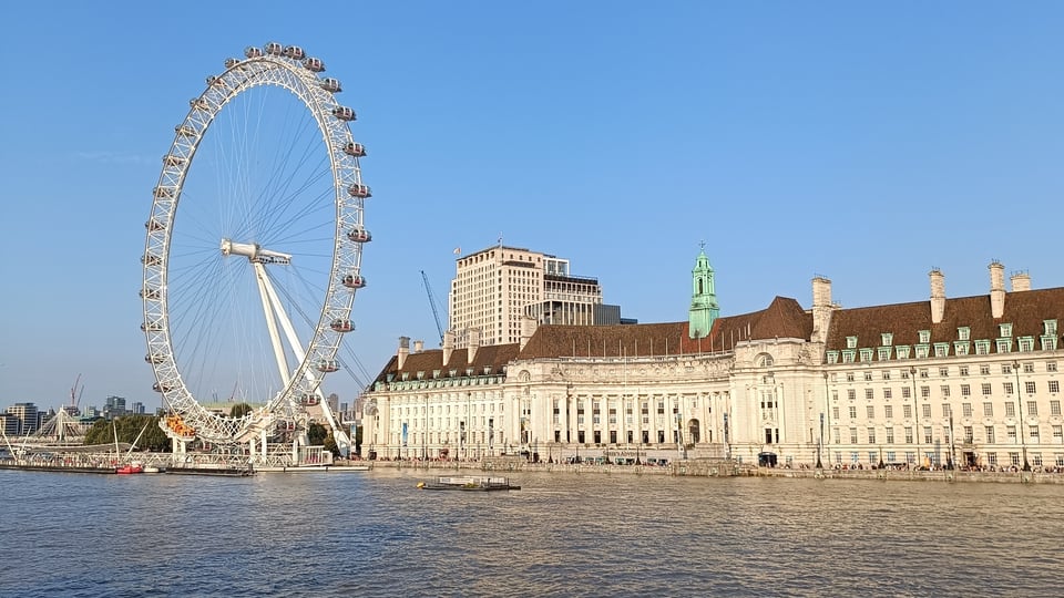 从 Westminster Bridge 望向 London Eye 与 County Hall，泰晤士河横过画面前方。